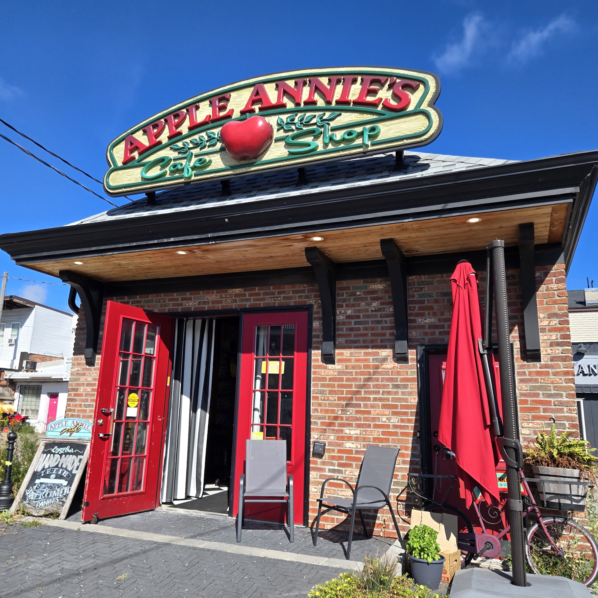 Apple Annie's Cafe storefront with red doors and the signature apple sign