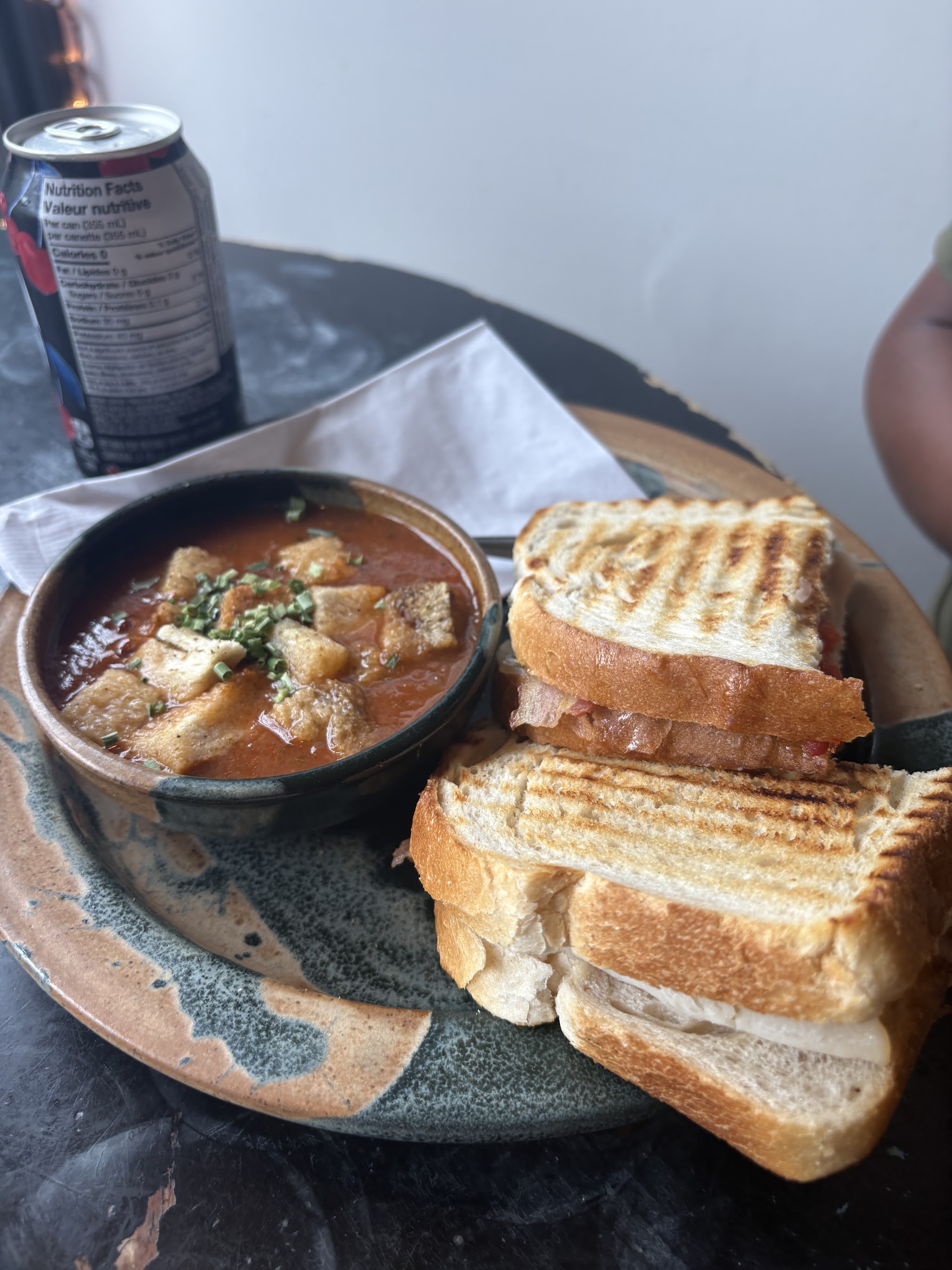 Grilled panini with tomato soup on handmade pottery