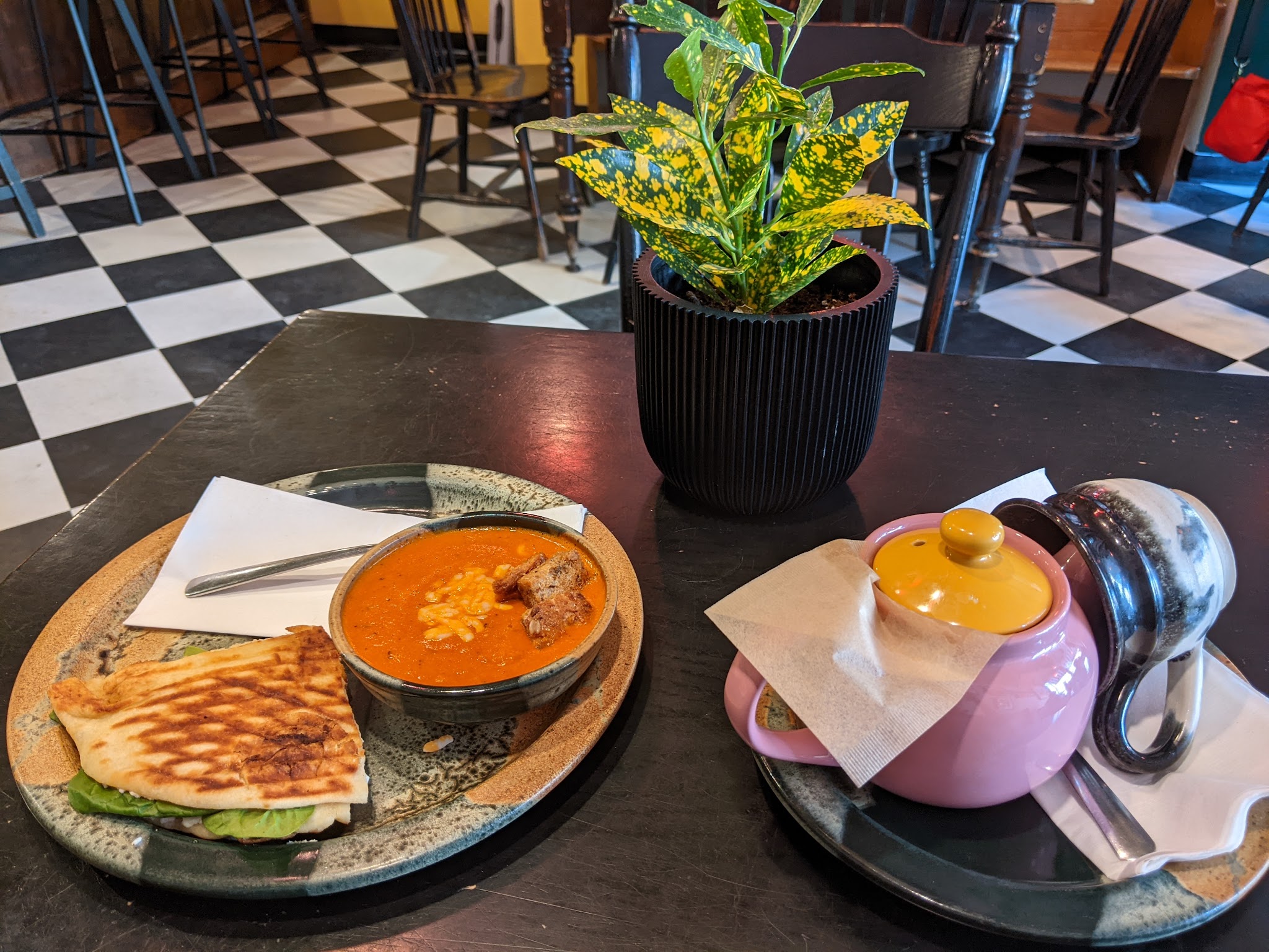 Panini and soup with a teapot on the table